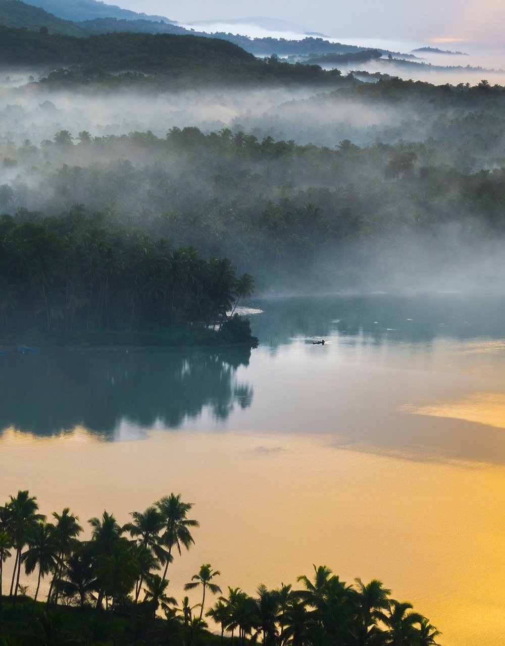 Mist rising off a still lake at sunrise, Western Ghats
