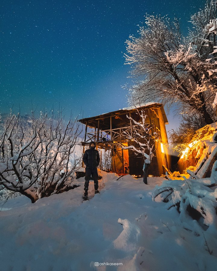 Mountain shelter at night under stars